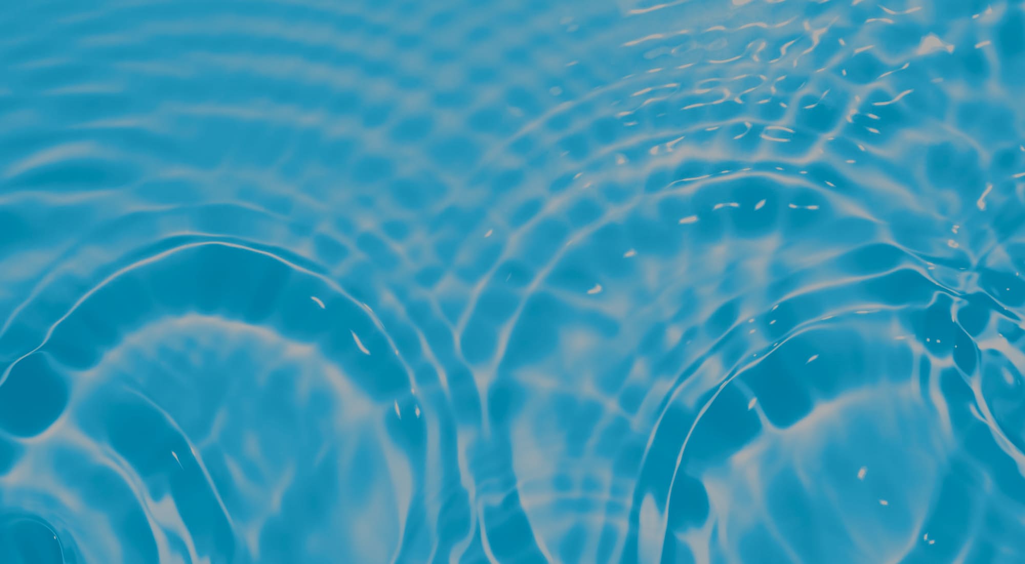 Concentric ripples spreading outward across pale blue water